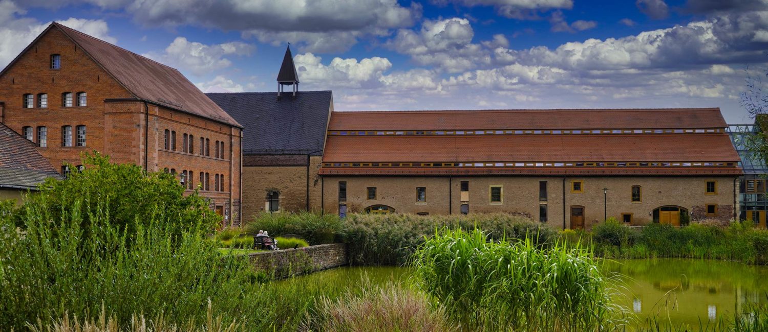 Kloster Helfta von außen mit Teich im Vordergrund