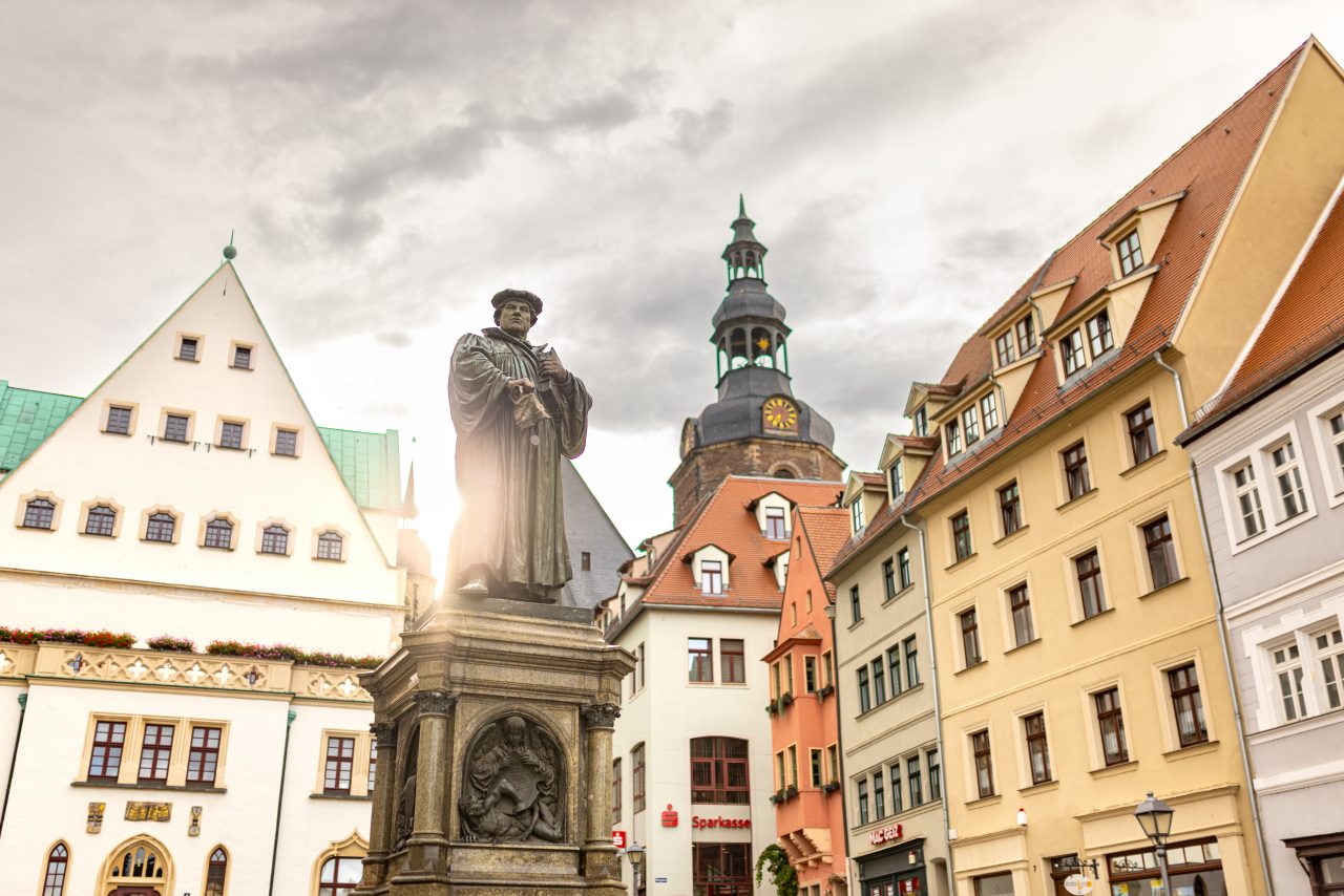 Luther Denkmal auf dem Marktplatz mit der St. Andreas Kirche und Gebäuden um den Marktplatz im Hintergrund