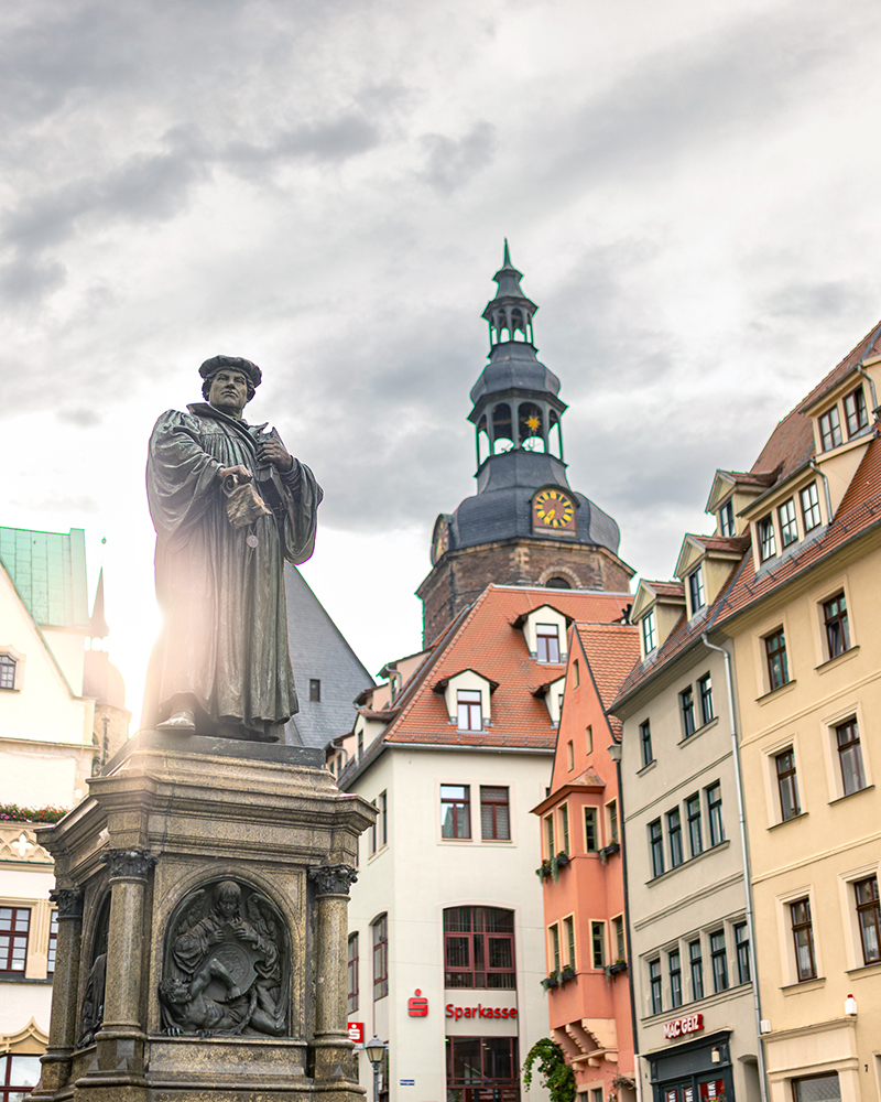 Luther Denkmal auf dem Marktplatz mit der St. Andreas Kirche und Gebäuden um den Marktplatz im Hintergrund